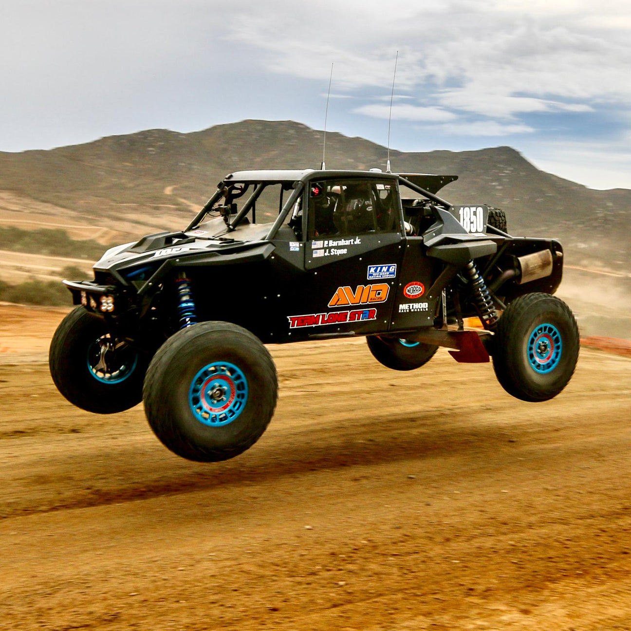AVID Racing Polaris RZR Pro R baja suspension kit mounted on race vehicle jumping on race track in sand dunes