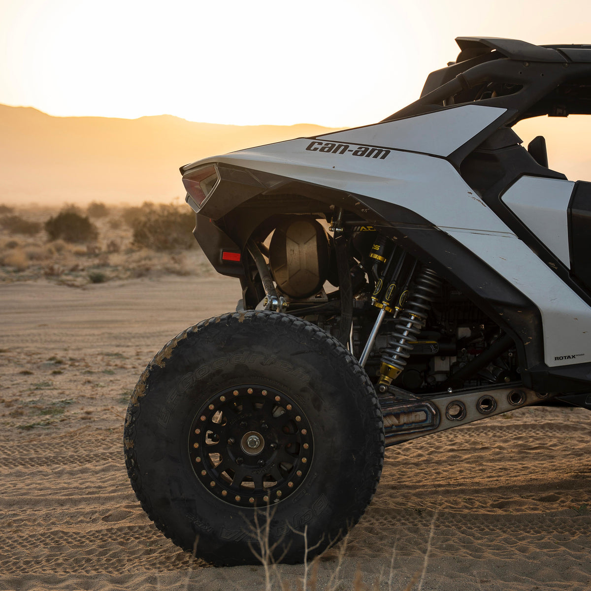 AVID Racing Can-Am Maverick R Rear Race Trailing Arm and Dual Shock Conversion Kit mounted on vehicle in the desert