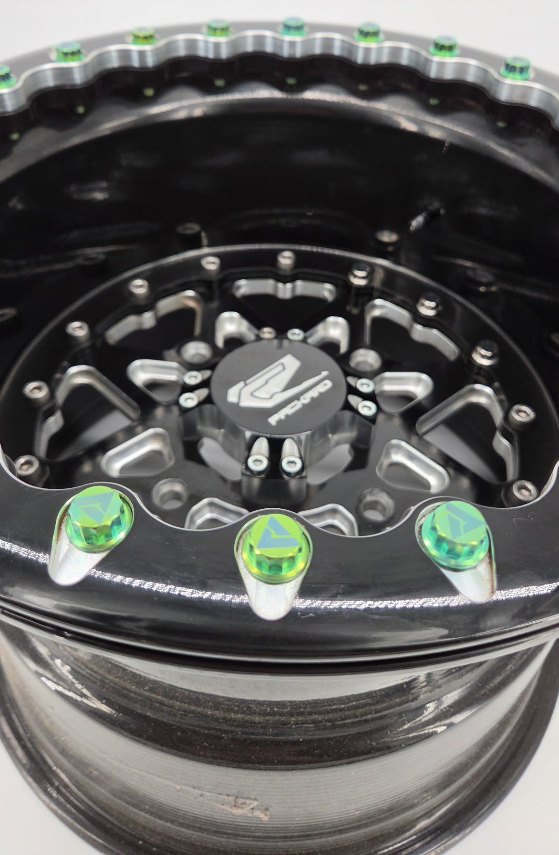 AVID Racing 12 point precision titanium hardware kit mounted on packard wheels anodized green close up view