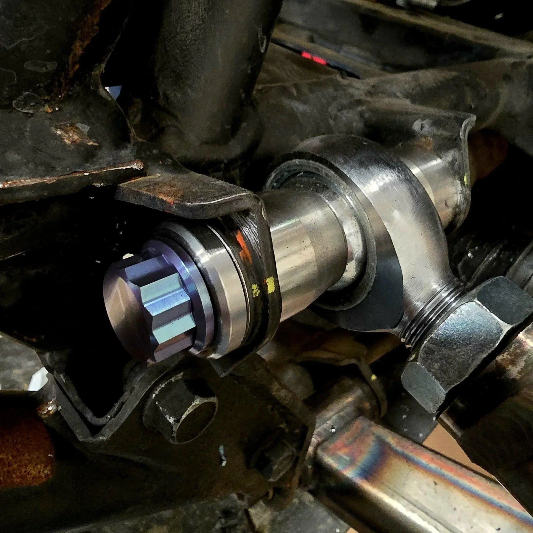 AVID Racing weld washer mounted on UTV suspension with a 12 point anodized titanium hardware